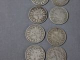 Plusieurs pièces d'argent sont alignées sur une surface grise