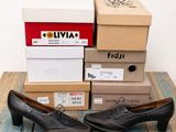 plusieurs cartons de chaussures posés sur une table en bois