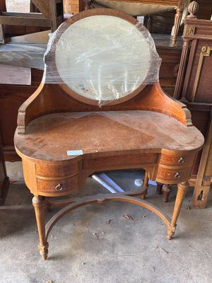 a wooden vanity with a mirror on top of it