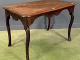 a small table with a wooden top on a green carpet