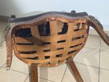 a wooden chair with a woven seat on a tiled floor