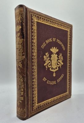 un vieux livre orné d'un emblème doré posé sur une surface blanche