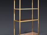 a brass bookcase with glass shelves on a dark background
