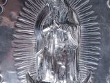 silver plate with the image of our lady of guadalupe on it