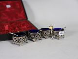 three silver and blue glass cups in a red case