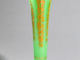 vase vert et doré sur fond blanc, avec une ombre au sol
