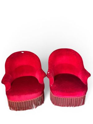 une paire de chaises en velours rouge avec des franges sur les pieds