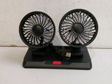 two small black fans sitting on top of a table