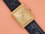 une image représentant une montre-bracelet posée sur une surface marron