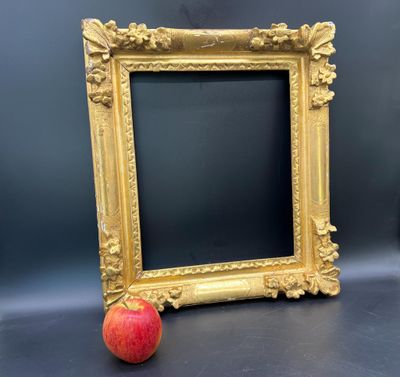 une pomme posée à côté d'un cadre photo sur une table