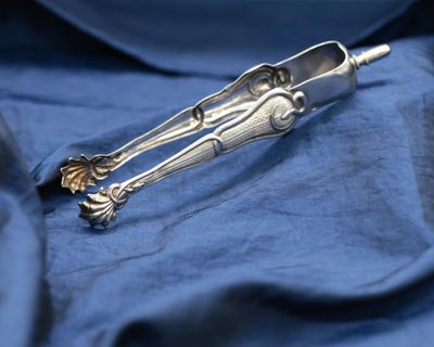 a silver spoon and spoon rest on a blue cloth