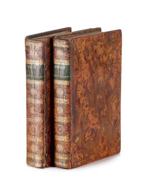 an old pair of books sitting on top of each other on a white surface