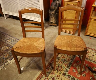 two wooden chairs sitting next to each other on a rug
