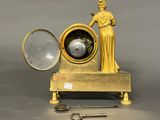 a statue of a woman holding a magnifying glass next to a clock