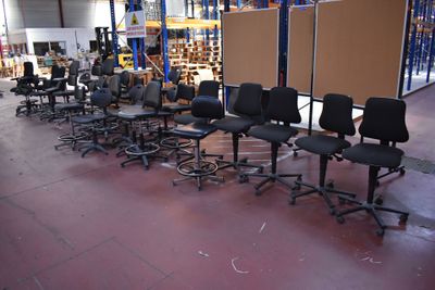a lot of chairs and tables in a warehouse