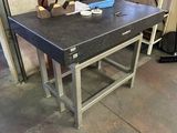une table de travail dans un garage, sur laquelle sont posés des outils