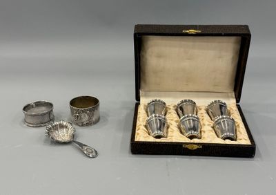 three silver cups and spoons in a box on a table
