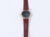 wrist watch on a white surface with a red strap