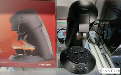 une cafetière noire posée sur un plan de travail, à côté d'une boîte de café