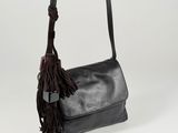 the black leather bag has a tassel hanging from it ' s strap