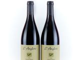 deux bouteilles de vin rouge posées l'une à côté de l'autre sur une surface blanche