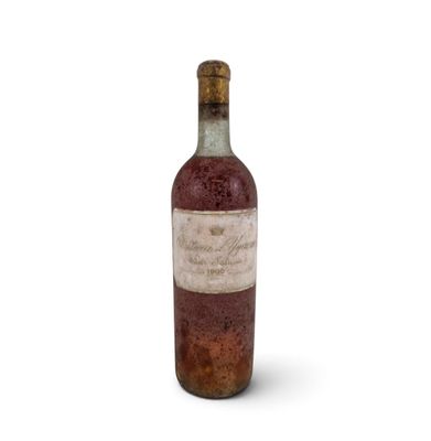 an old bottle of wine sitting on top of a white surface