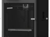 une imprimante 3D noire posée sur une surface blanche