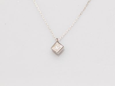 un pendentif en forme de diamant blanc suspendu à une chaîne, sur fond blanc
