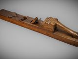an old wooden plane with a wooden handle on a gray background