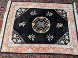 tapis oriental à motifs orientaux sur fond noir, avec une bordure rouge