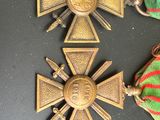 deux médailles et un ruban posés sur une table, accompagnés d'un ruban rayé rouge et vert