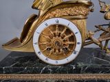 a gold clock that is sitting on a marble base