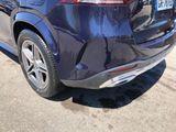 the rear end of a blue car parked on the side of the road