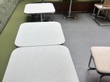 tables and chairs are lined up in a room with a green wall