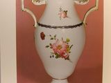 an old picture of a vase with flowers on it on a pink background