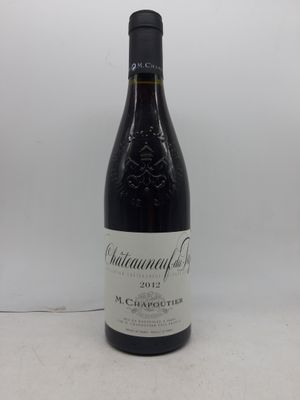 la bouteille de vin est posée sur la table à côté du mur