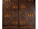 une vieille armoire en bois avec des sculptures et des gravures sur les portes