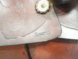 a close up of a horse ' s saddle on a brick floor