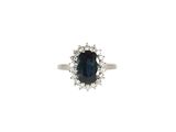 gros plan d'une bague avec une pierre bleue entourée de diamants blancs