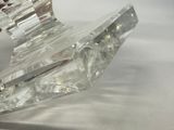 a clear glass object on a white surface