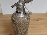 a metal bottle with a metal handle on a wooden table