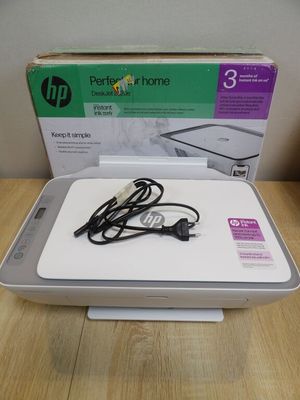 a white hp printer sitting on top of a wooden table next to a box