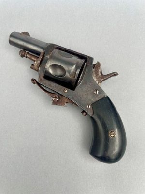 un vieux pistolet posé sur une surface blanche