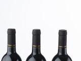 three bottles of wine sitting on top of a white table