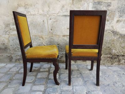 two chairs sitting next to each other on a cobblestone floor