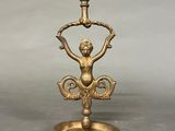 an image of a gold candle holder with a statue on it