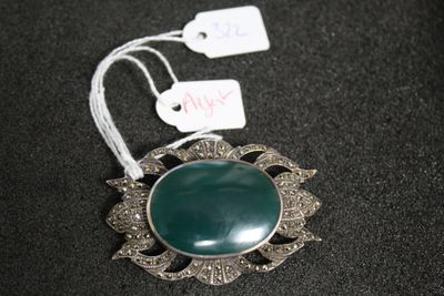 une photo d'un collier orné d'une pierre verte