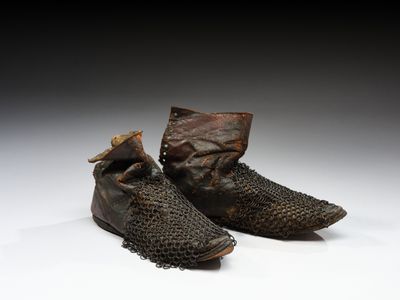deux paires de chaussures ornées de chaînes, posées sur une surface blanche