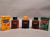 four different types of perfumes are lined up on a white surface