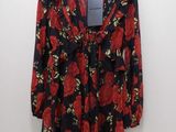une robe à fleurs noire et rouge suspendue à un cintre